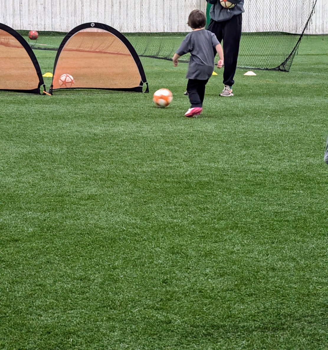 child playing soccer at indoor field