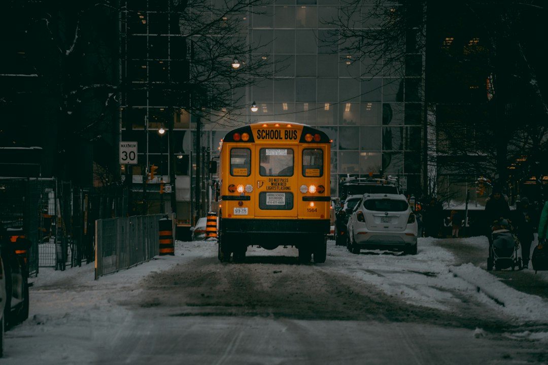 a yellow school bus driving down a snow covered street