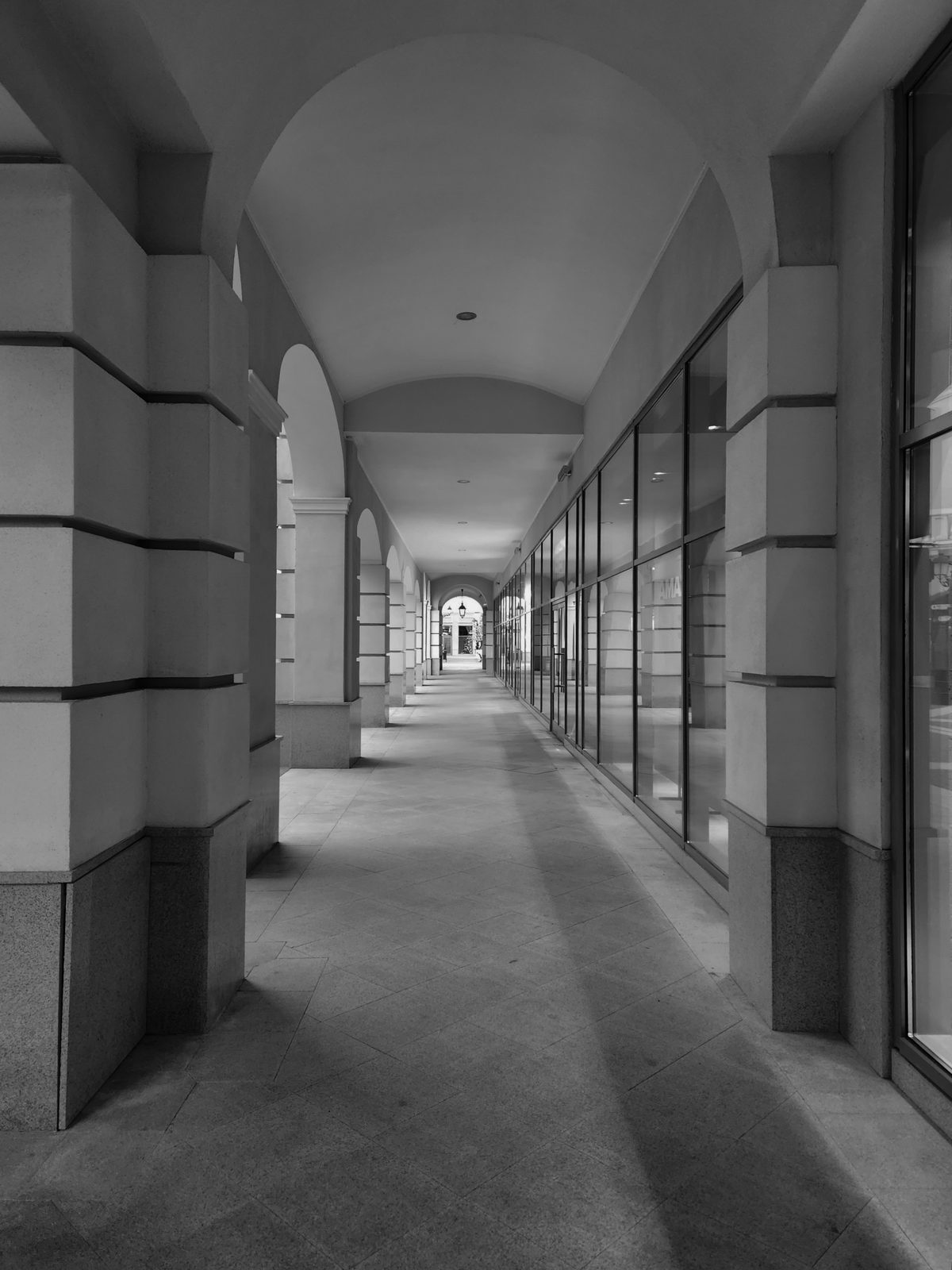 a black and white photo of a long hallway